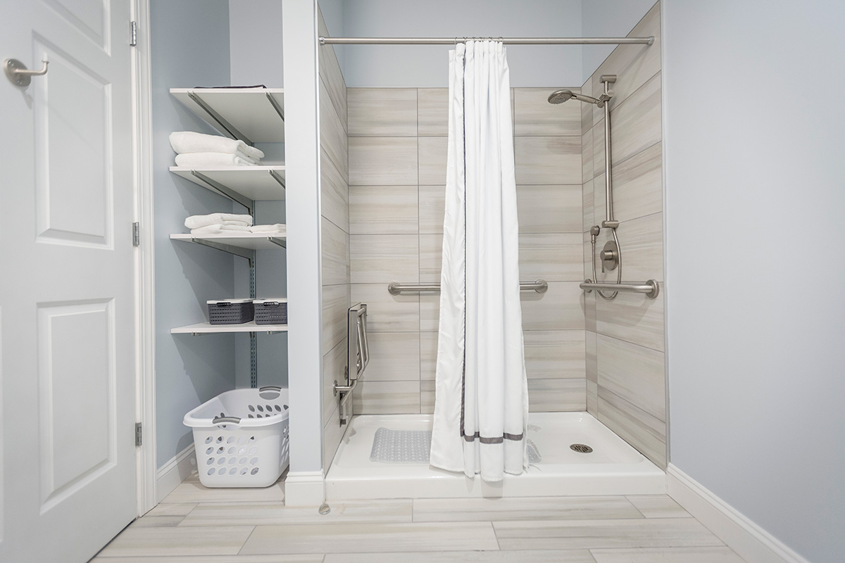 Tile walk-in shower with curtain and towel shelves