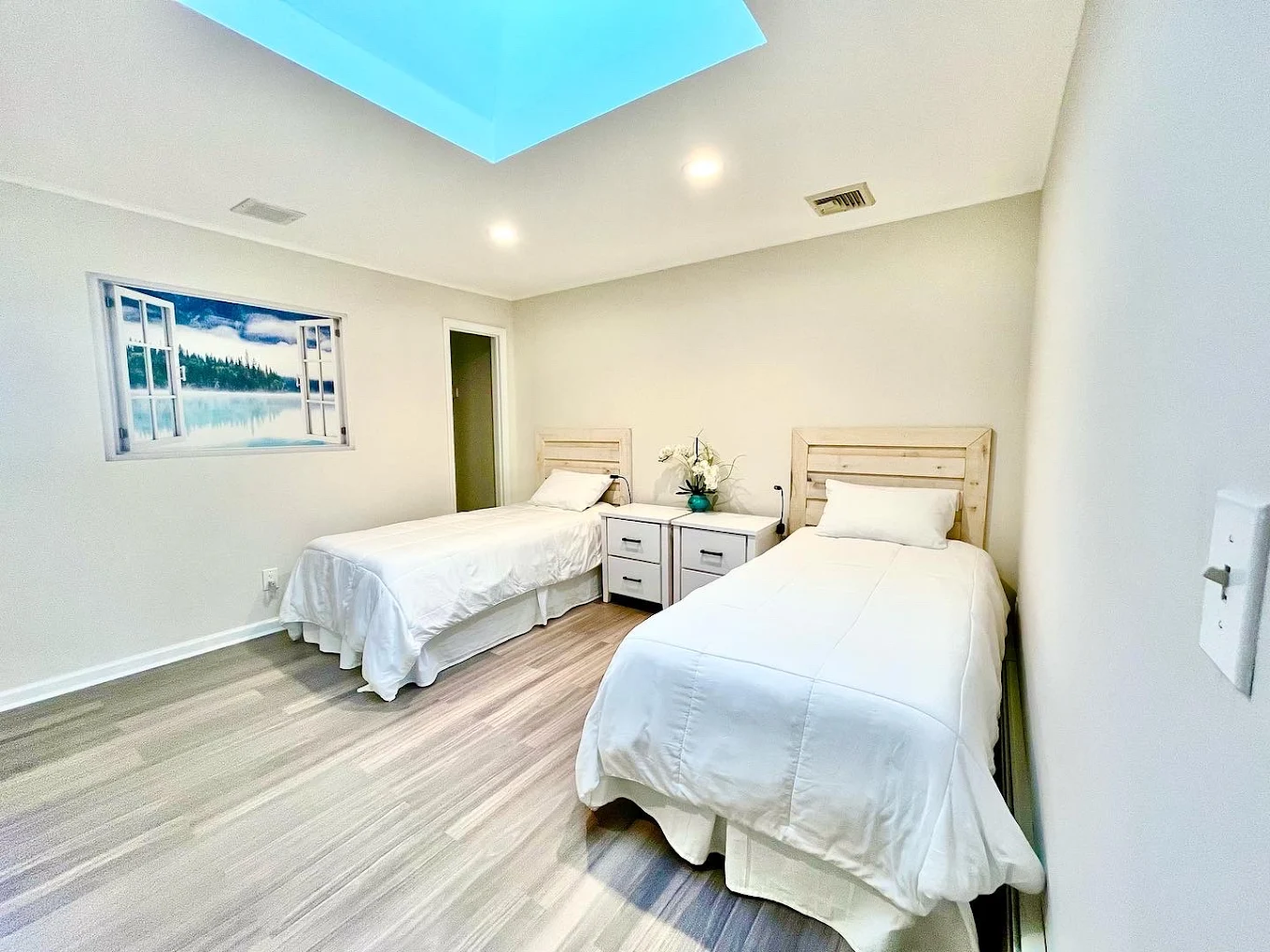 Bright shared bedroom with two twin beds and skylight