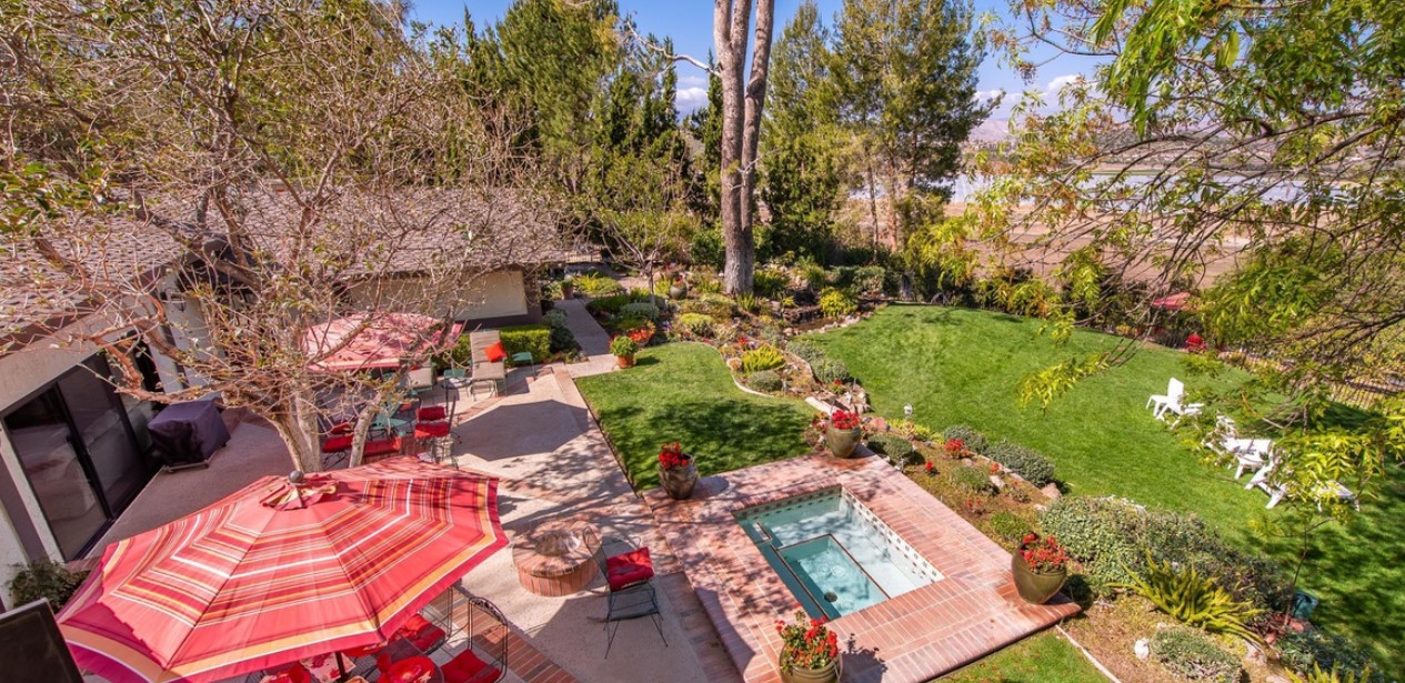 Facility backyard with a spa and seating.