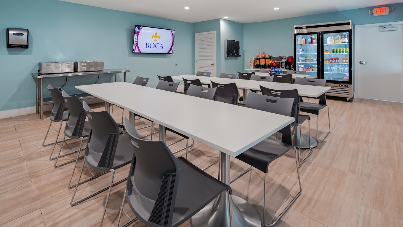 Dining area with seating, a large TV, and drink coolers.