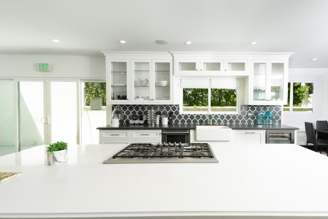 White modern kitchen with island and gas cooktop