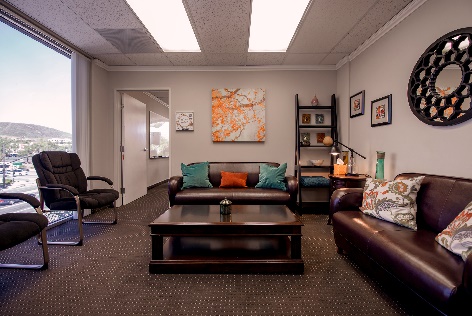 Bright lounge with leather sofas, wall art, and large windows