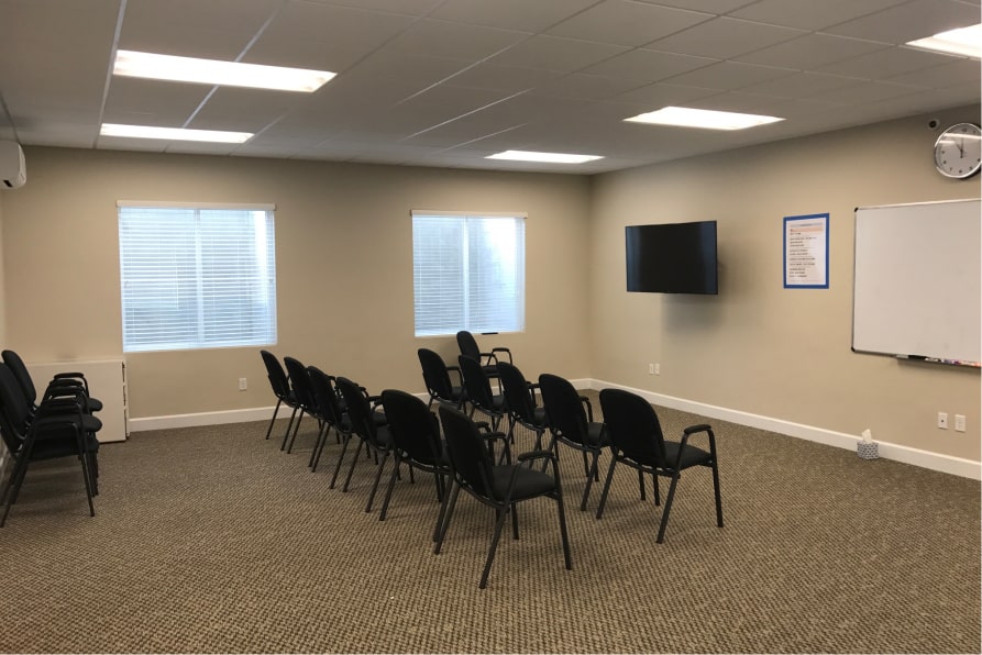 Room with rows of chairs and a TV for group sessions