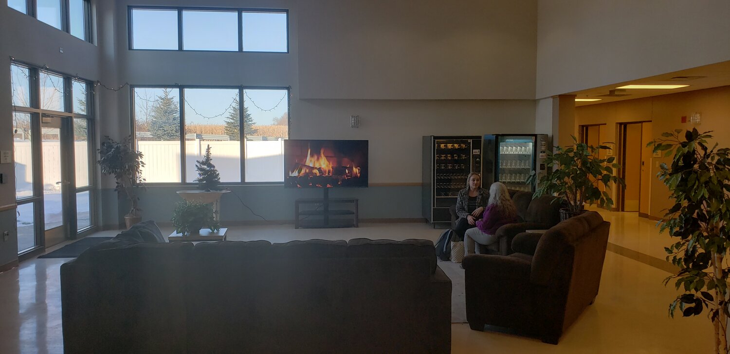 Large lounge with couches, fireplace TV, and vending machines