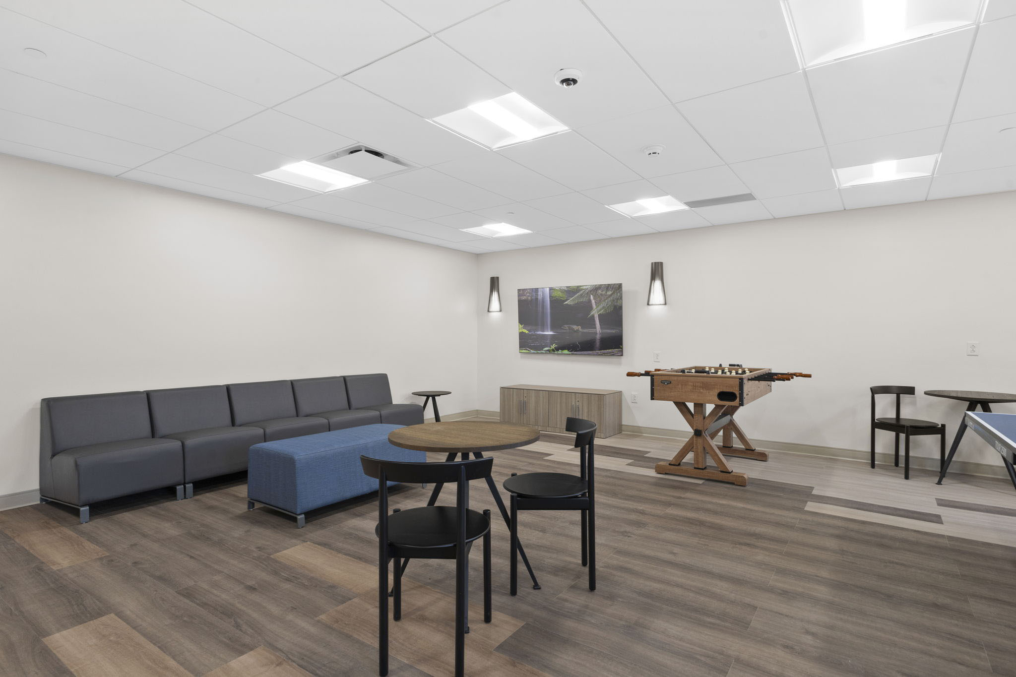 A lounge area with games, tables, and a foosball table.
