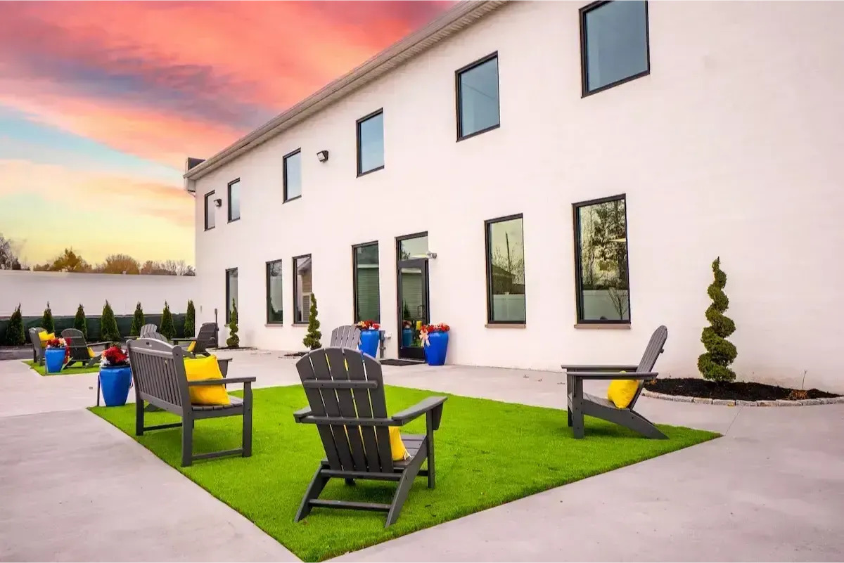 Outdoor seating area with chairs and bright planters.