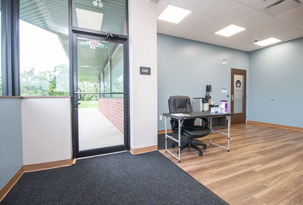 Entrance area with desk, glass door, and wood flooring