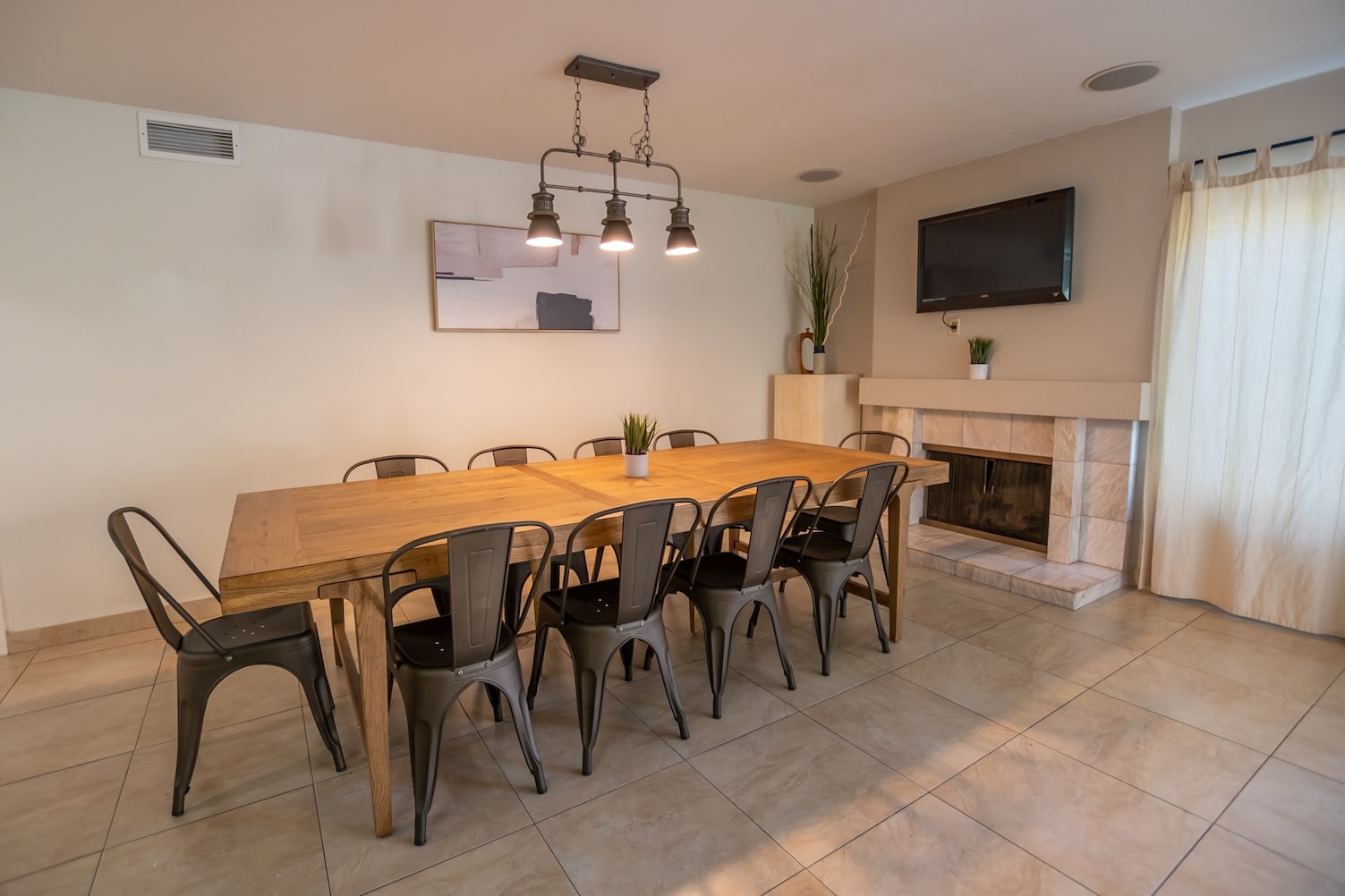 A dining area with a wooden table, chairs, and a fireplace.