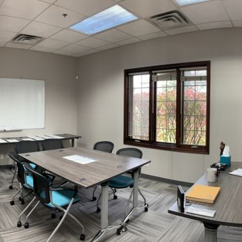 Conference room with tables, chairs, and whiteboard