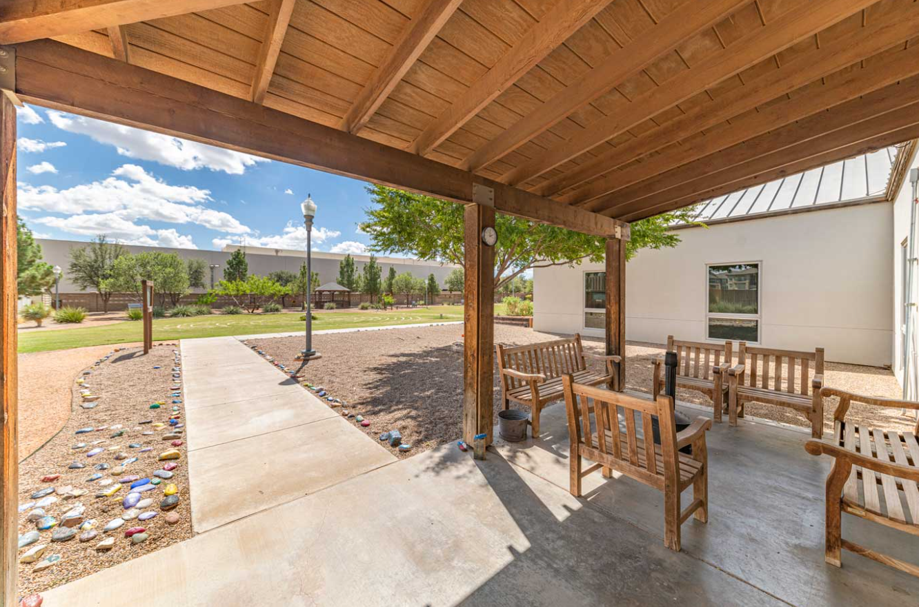 Covered outdoor patio with seating and walking paths