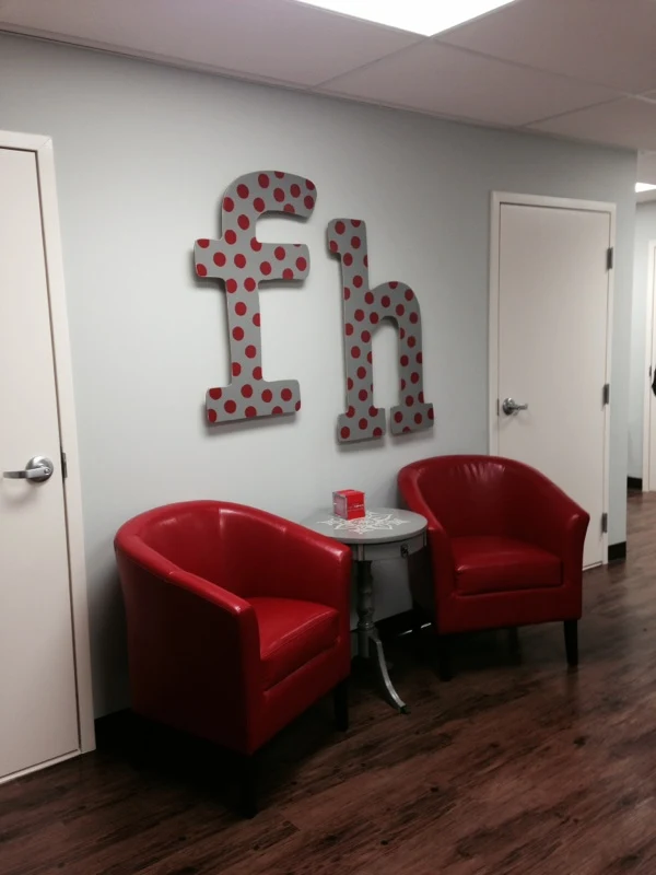 Lobby with two red chairs and polka dot wall art