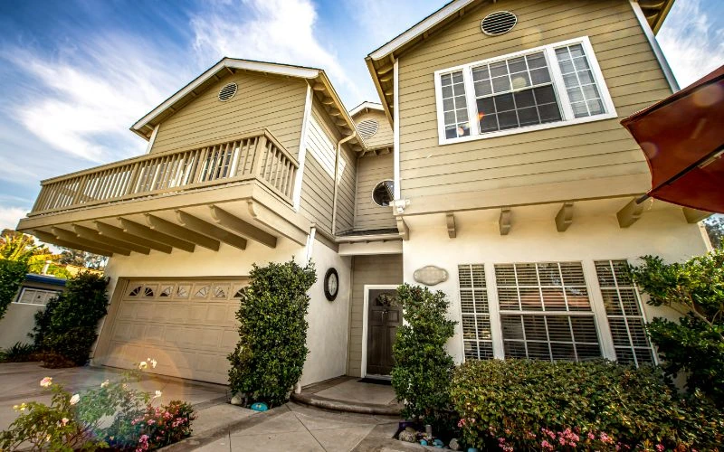 Residential-style exterior with garage and lush landscaping