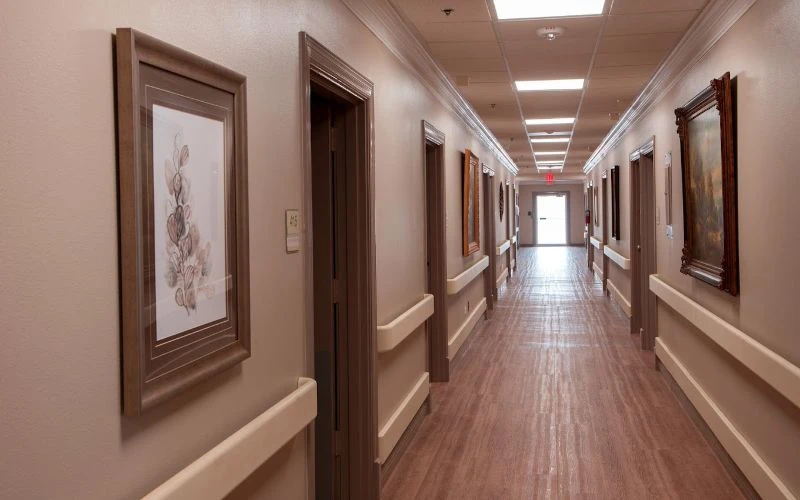 Long hallway lined with framed art and soft lighting