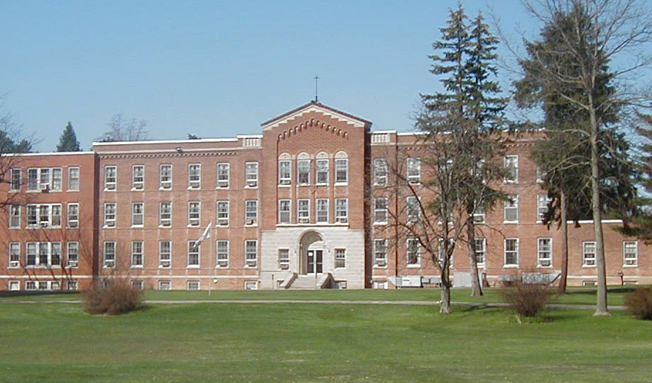 Historic red-brick rehab facility with large lawn and central entrance.