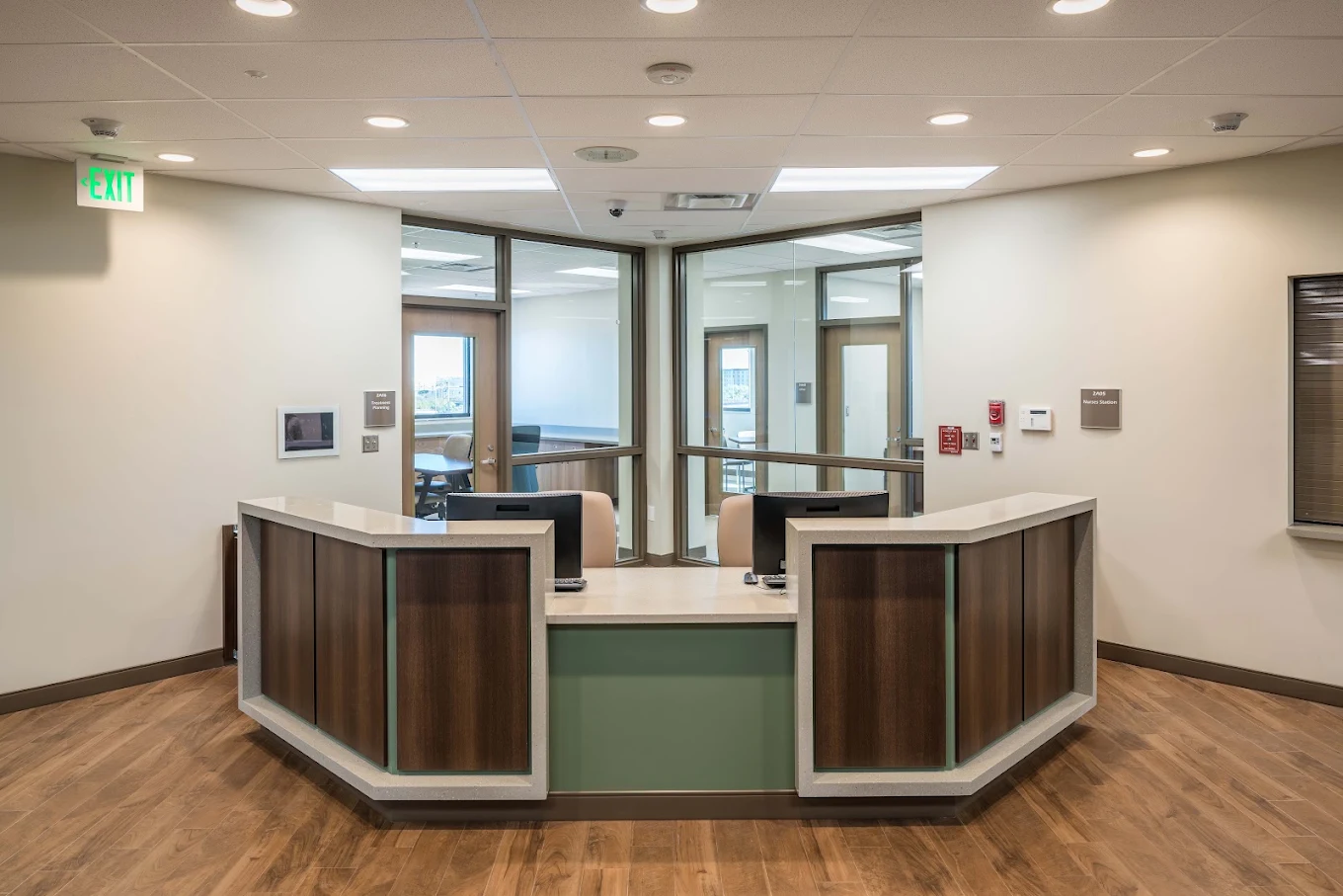 Reception desk with patient rooms visible behind it.
