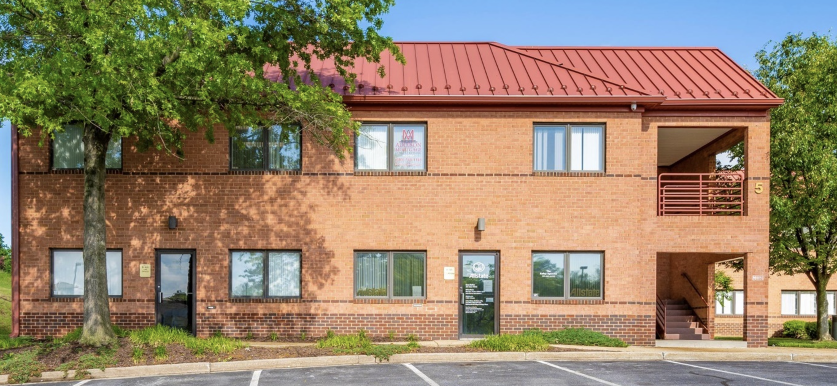 A bright, red-brick counseling center with a welcoming entrance, complemented by a tree-lined parking area for convenience.