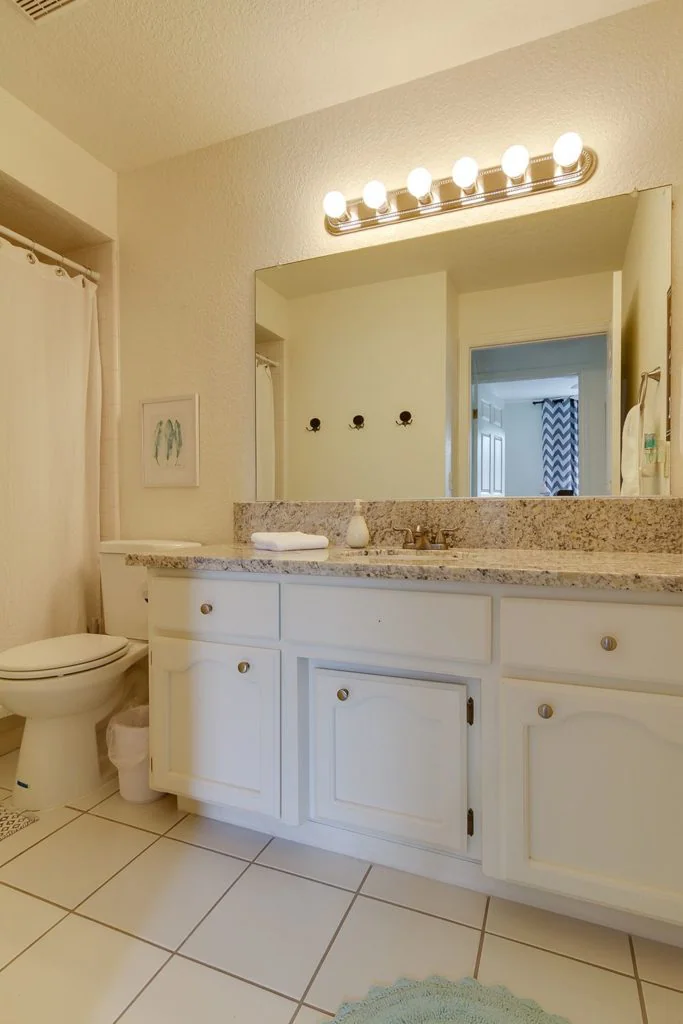 Clean bathroom with granite countertop and vanity lights