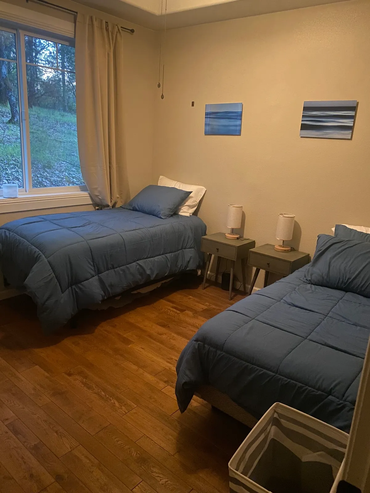 Shared bedroom with two twin beds and a window facing nature