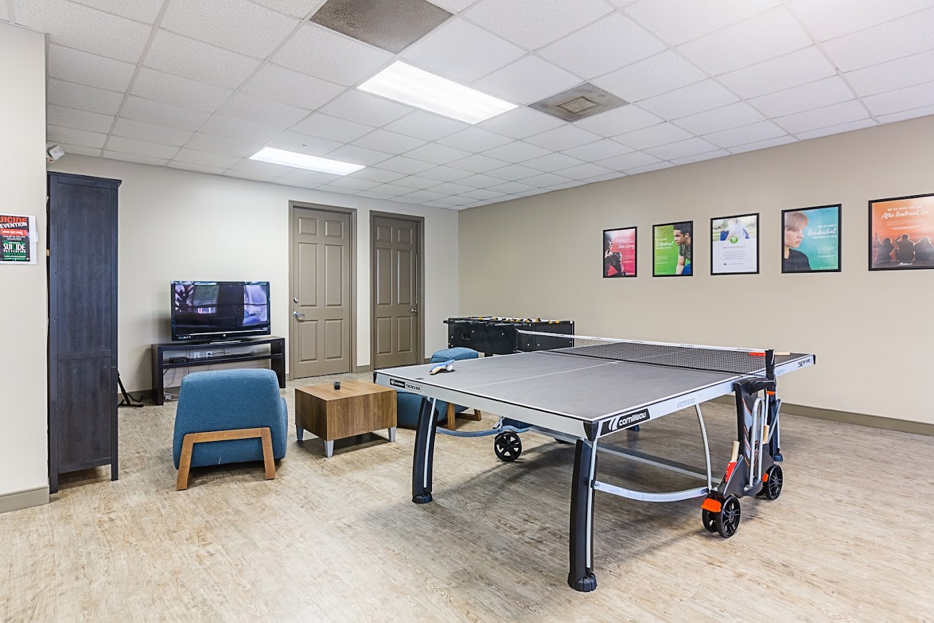 Recreation room with a ping pong table, TV, and seating area.