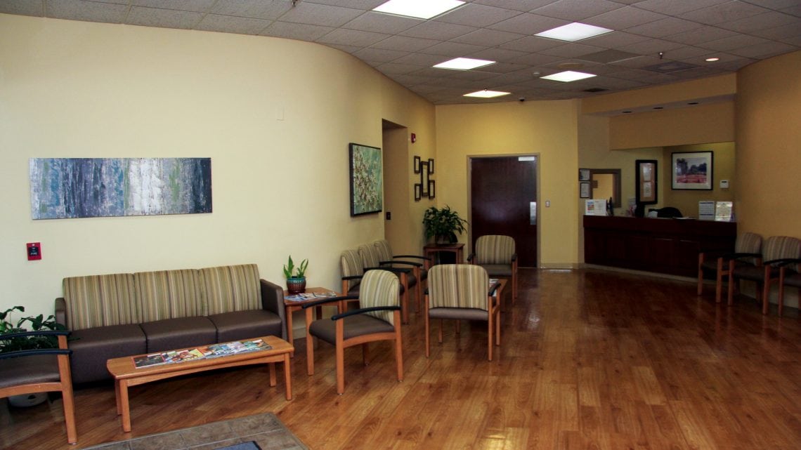 Wood-floored lobby with striped chairs and wall art