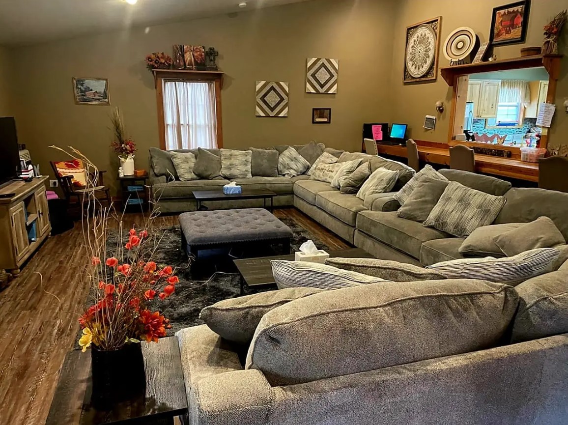 Cozy living room at Kisa Life Recovery Sedan with a large sectional sofa, soft lighting, and inviting decor.
