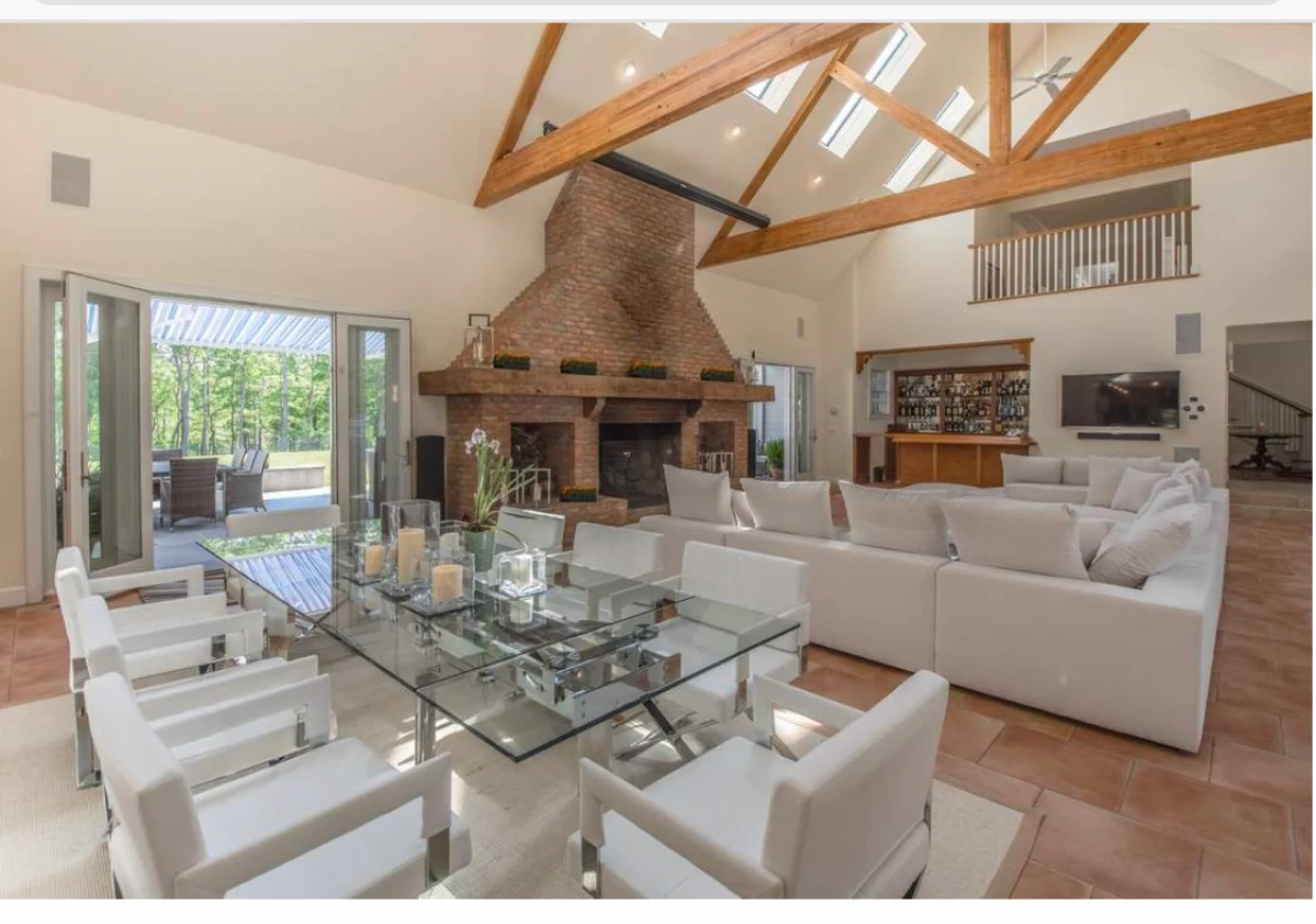Bright room with glass dining table and white sofas