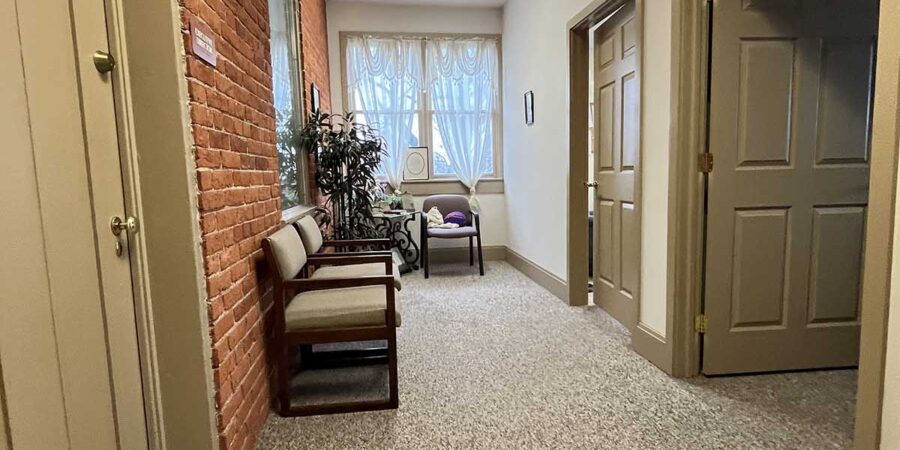 Carpeted hallway with seating and plants