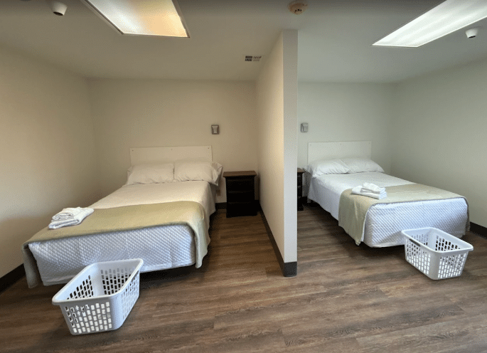Shared bedroom with two beds and laundry baskets