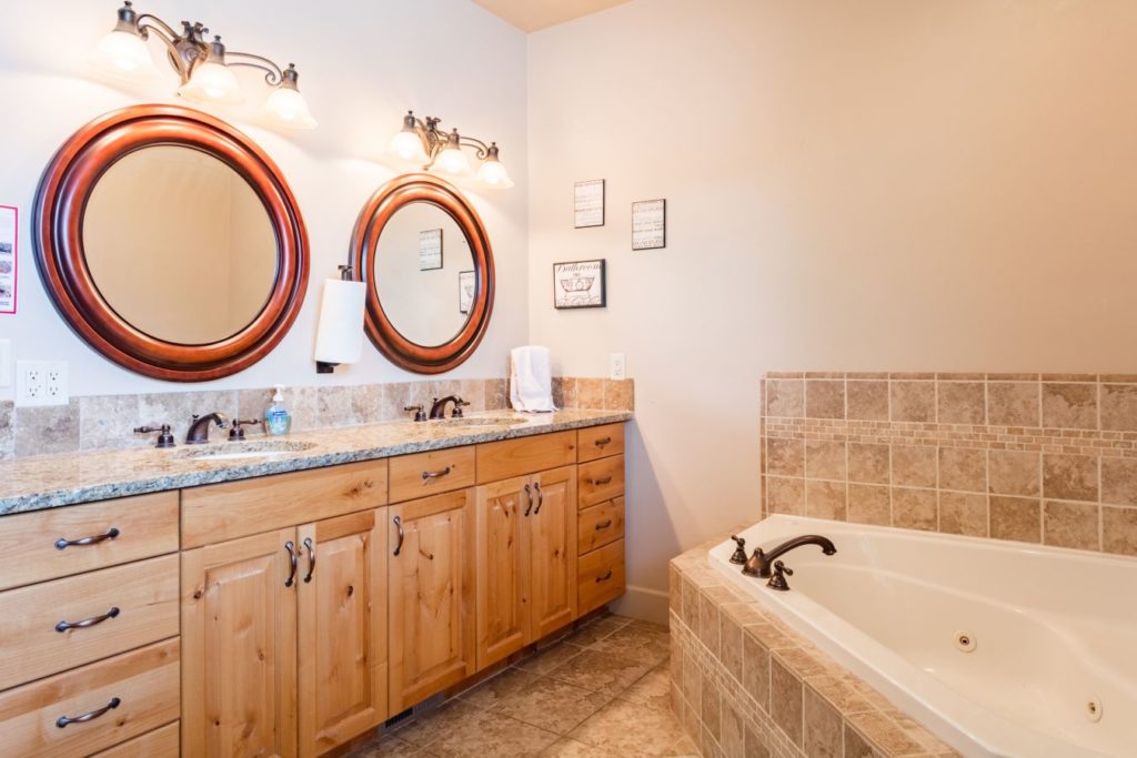 Bathroom with double sinks and a large soaking tub.