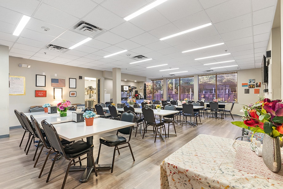 Spacious dining area with tables, chairs, and floral centerpieces