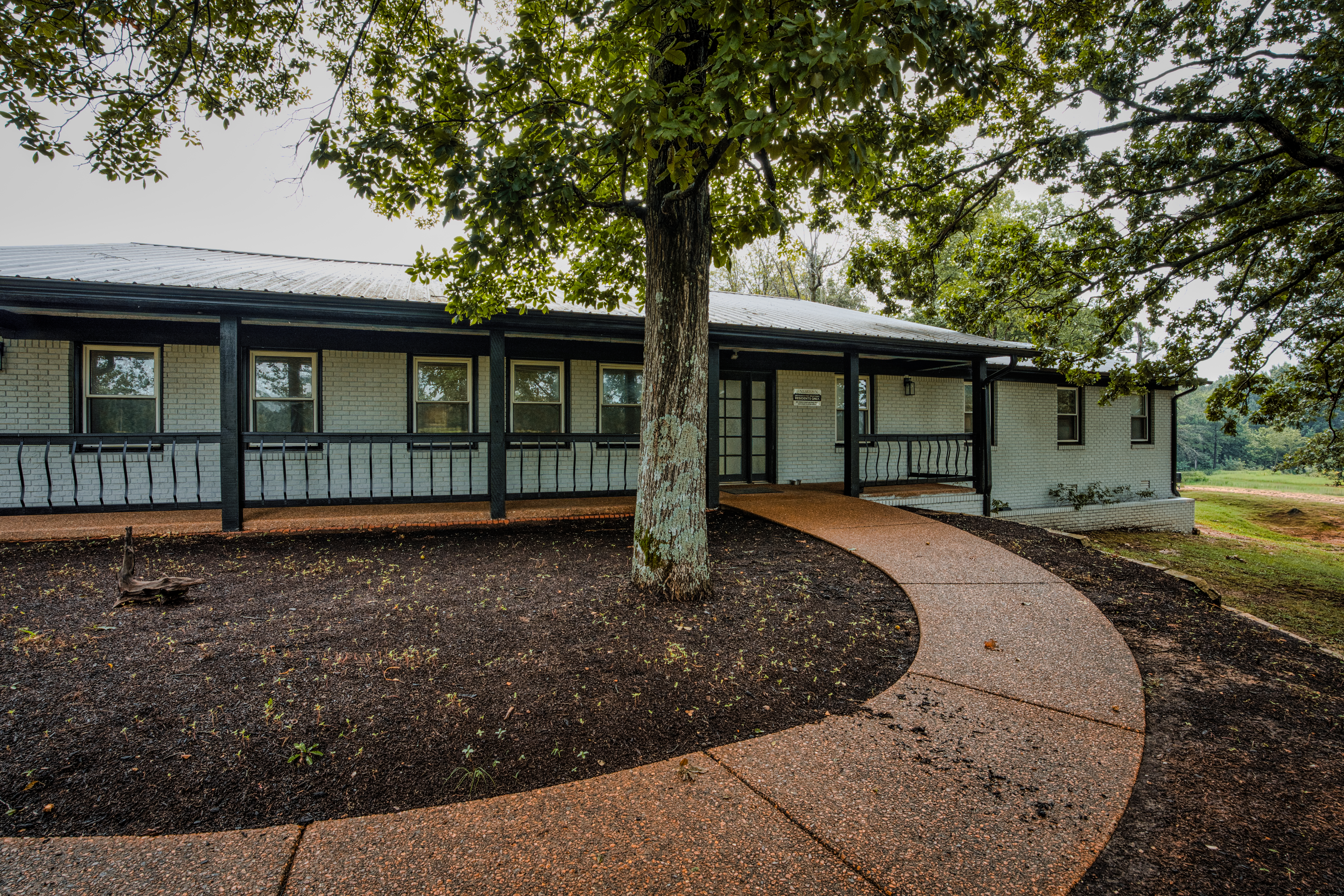 Main entrance featuring welcoming curved walkways and mature trees