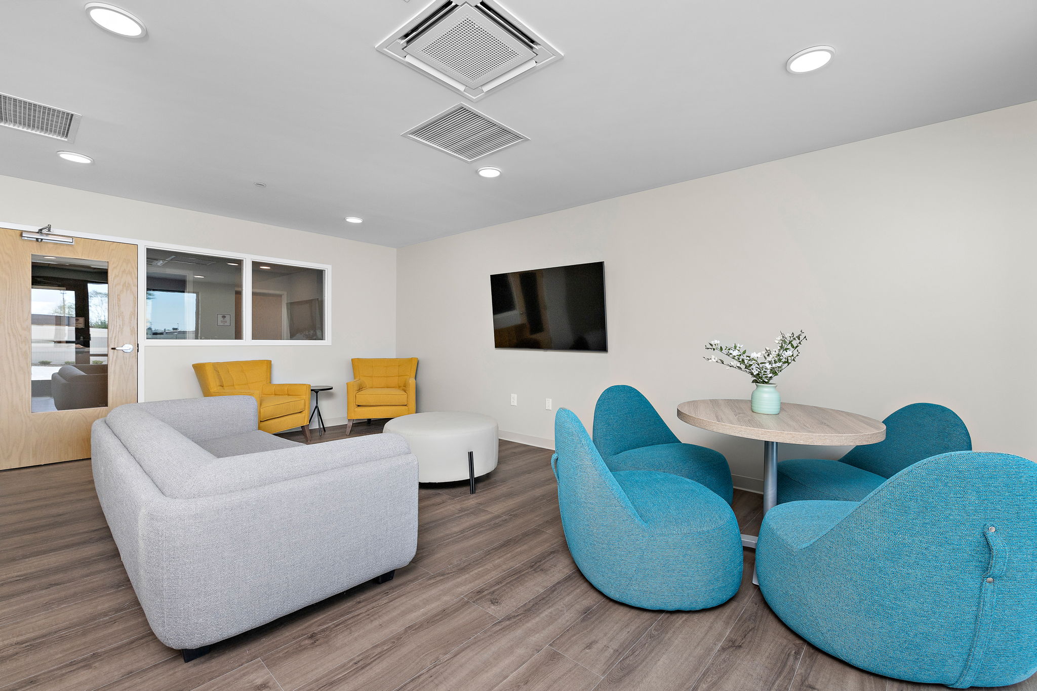 Lounge with TV, sofas, and modern blue chairs