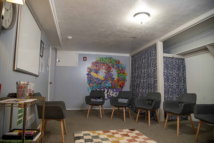 Group meeting room with chairs and colorful tree wall art