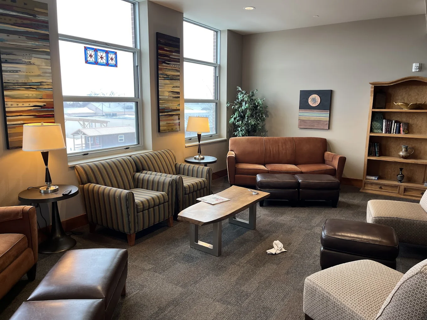 Cozy lounge with sofas, chairs, and a bookshelf