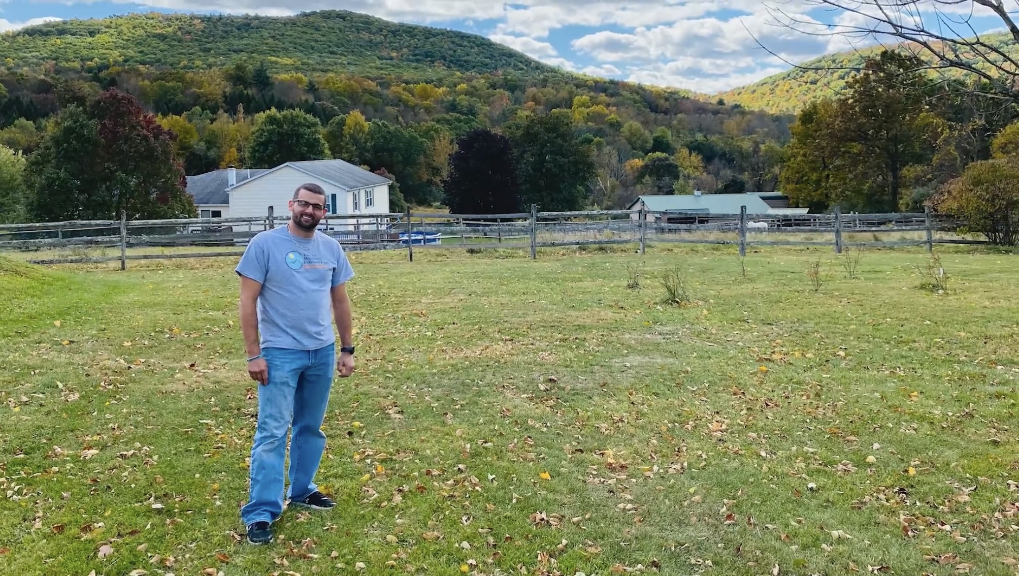 Rolling hills and forested mountains behind facility