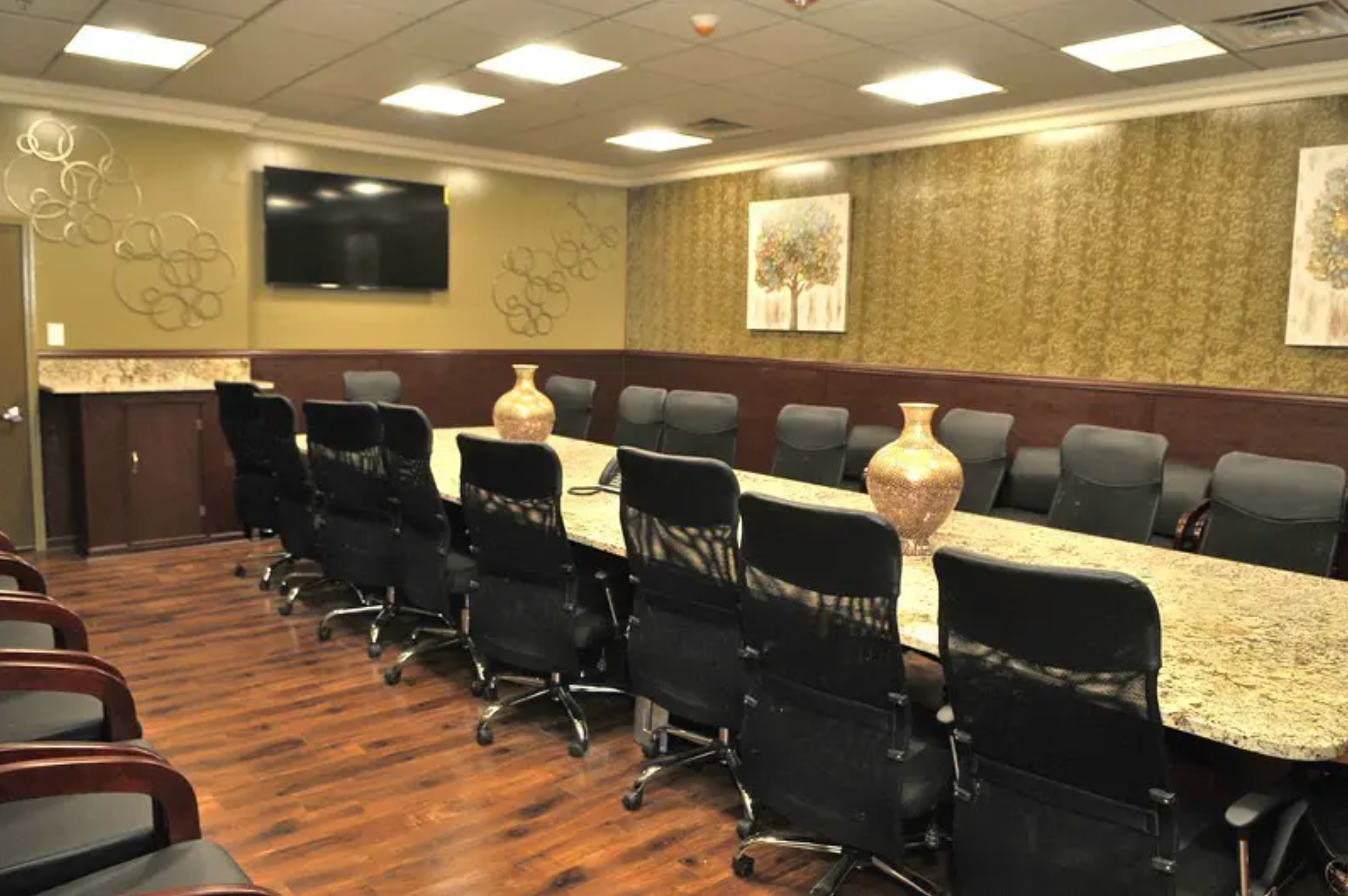 A spacious and professional conference room with a large table and ergonomic chairs.