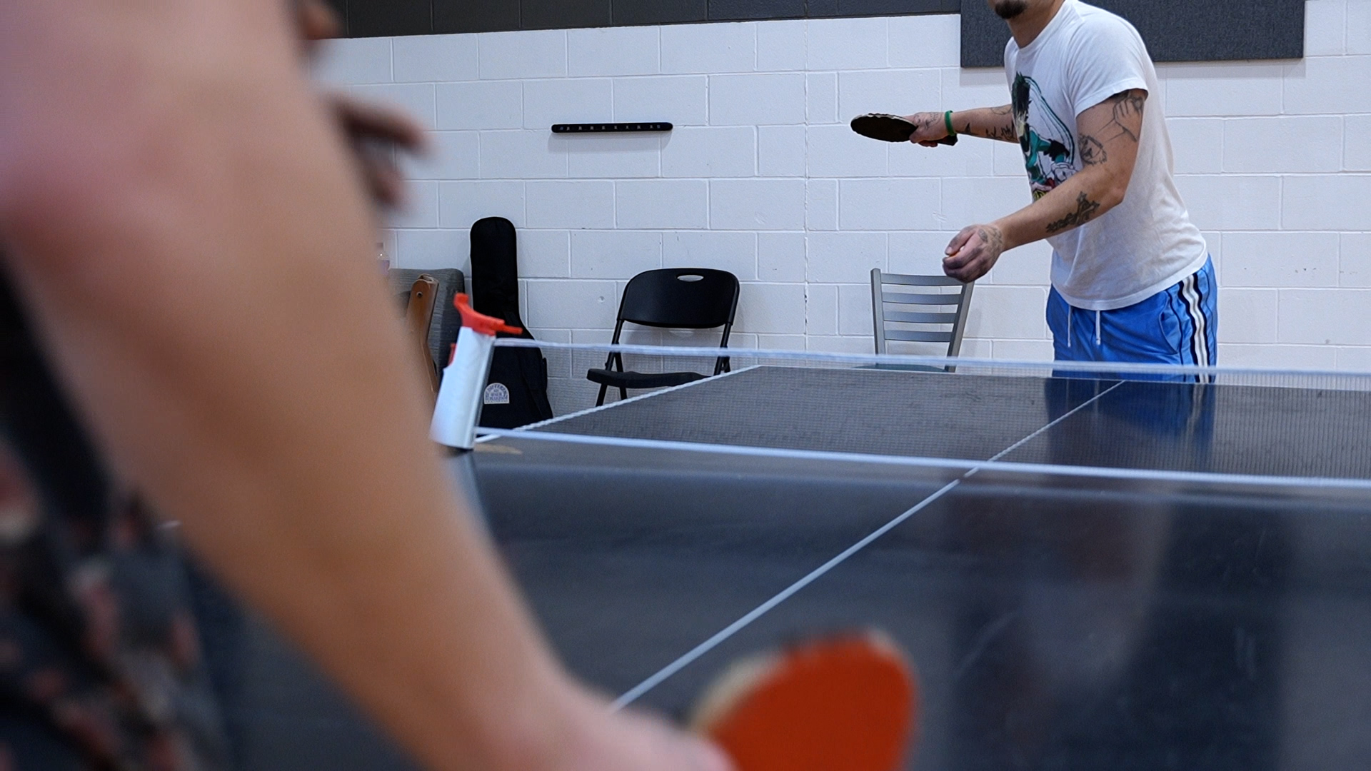 Two people playing ping-pong in recreation area