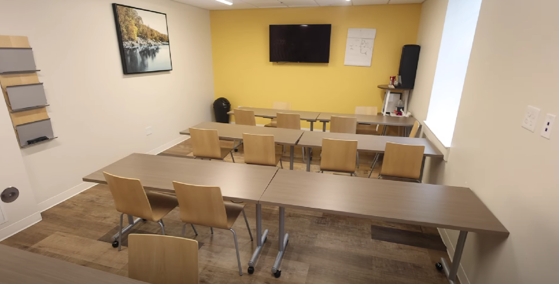 Classroom-style group therapy room with tables and chairs