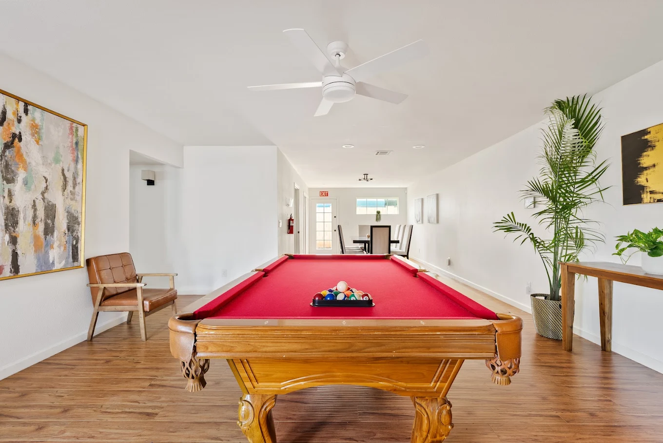 Recreation room with red pool table and wood flooring