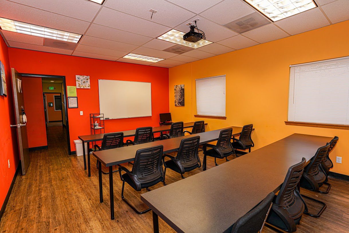 Classroom-style meeting space with orange accent wall