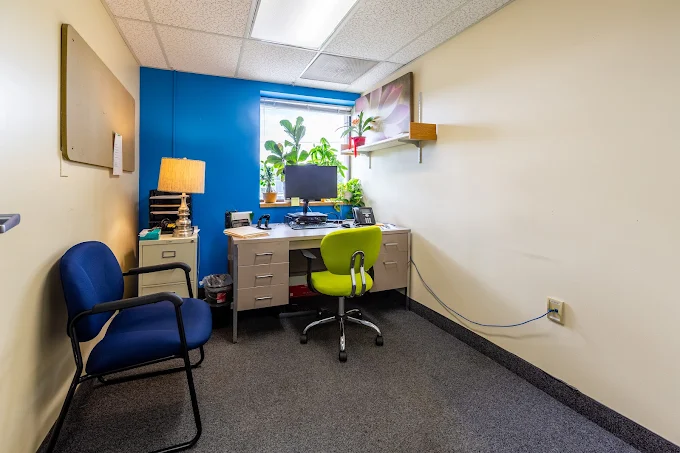 Office with desk, computer, lamp, and guest chair