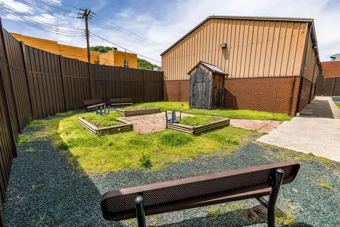 Secure outdoor courtyard with garden beds and benches