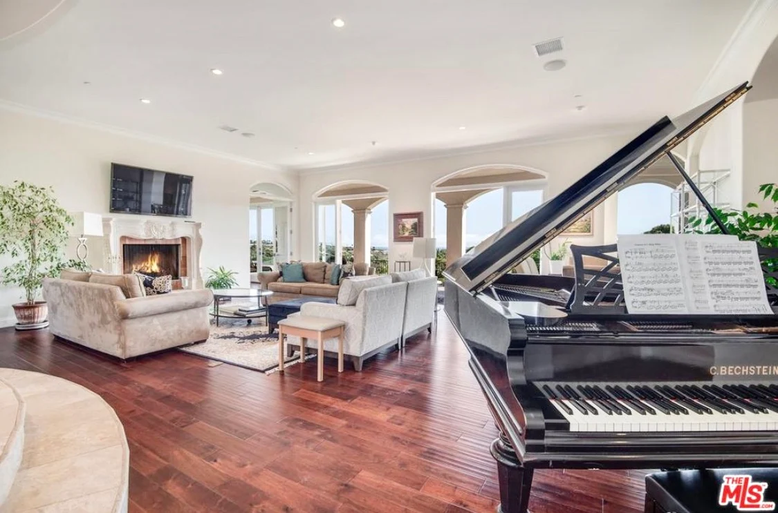 Grand piano in bright lounge with fireplace and seating