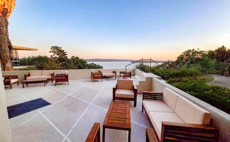Outdoor patio seating overlooking trees and lake views