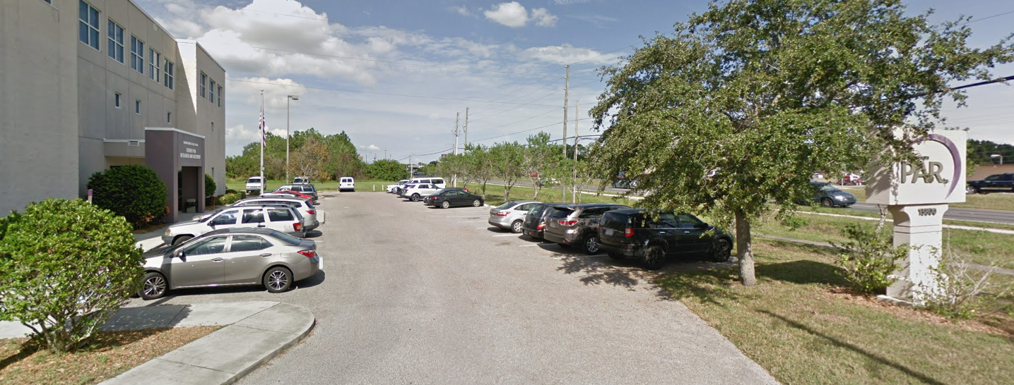 Rehab facility parking lot with PAR sign and vehicles