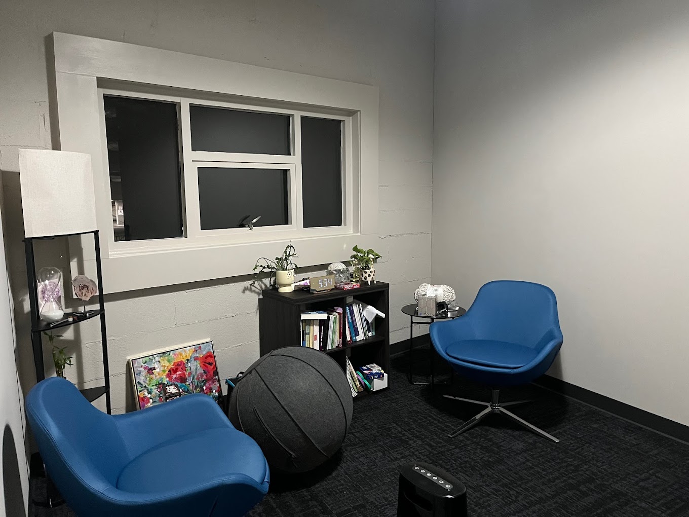 A therapy room with blue chairs and modern decorations.
