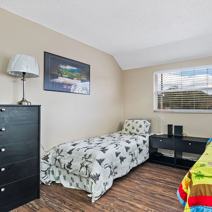 Shared bedroom with twin beds, furniture, and nightstands.