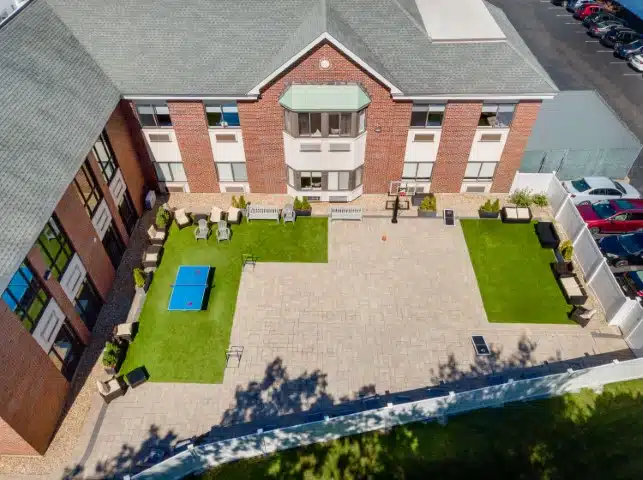 Outdoor courtyard with seating and a ping pong table.