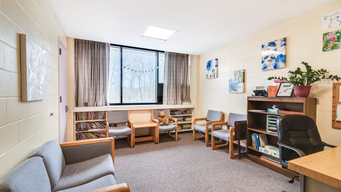 Therapy office with bookshelves and soft seating