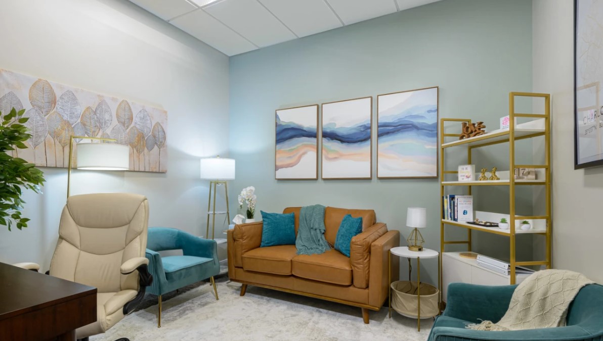 Therapy room with a couch and desk.